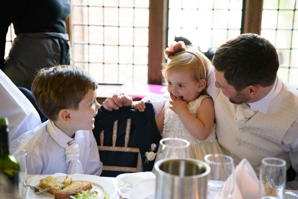 Children smiling and sharing a happy moment at the wedding.
