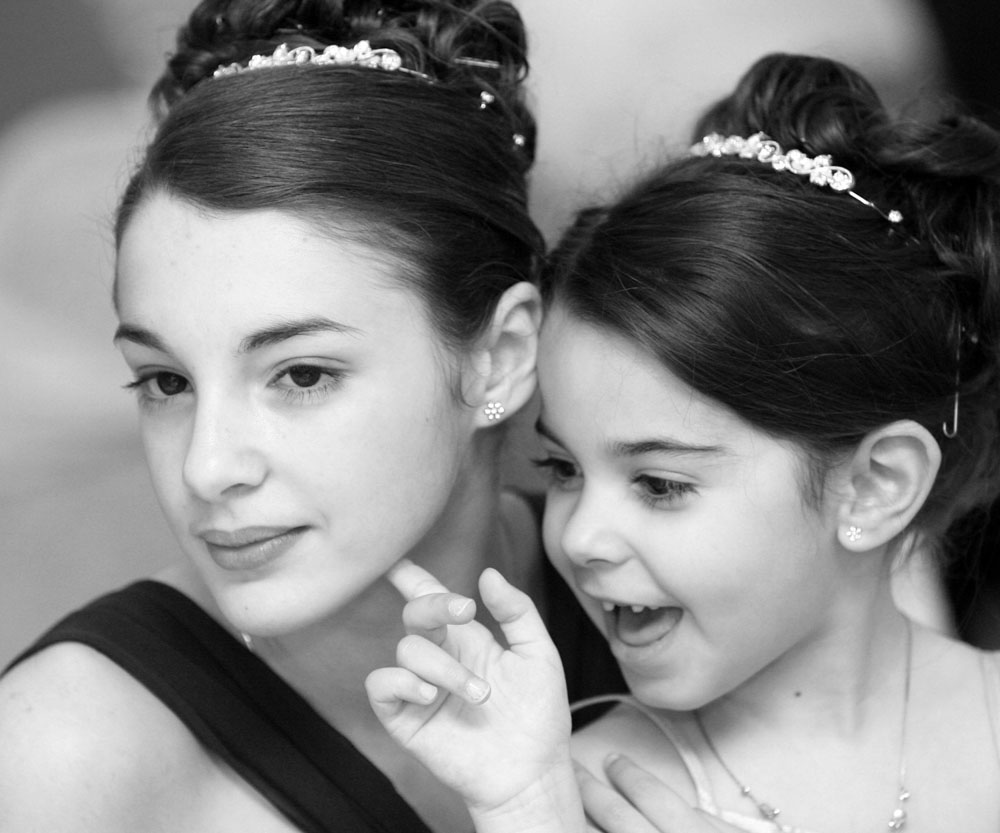 Sisters laughing together at an Italian wedding in elegant black and white