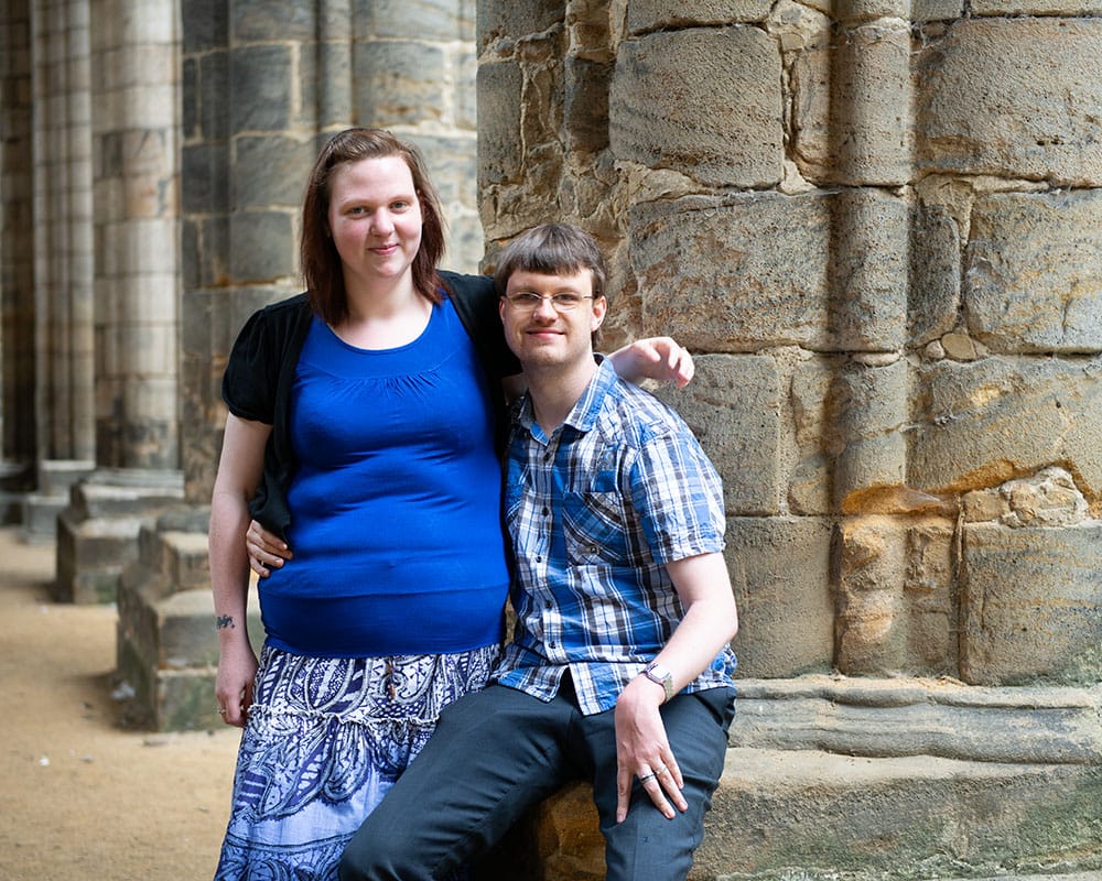 Rachel standing beside Robert, both sharing a loving look in the soft Kirkstall light.