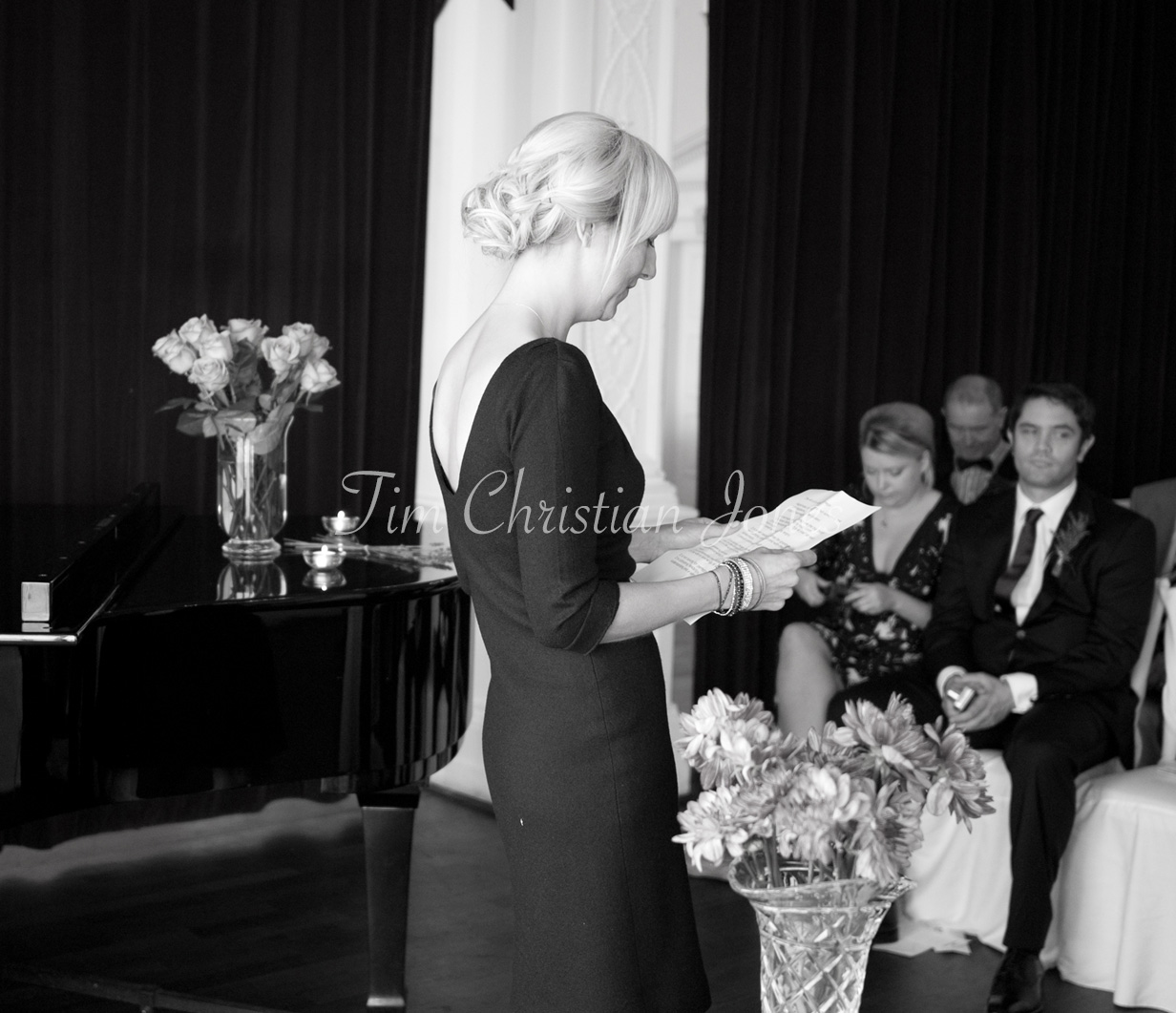 A guest reading during the ceremony, captured in black and white at the Trafalgar Tavern.