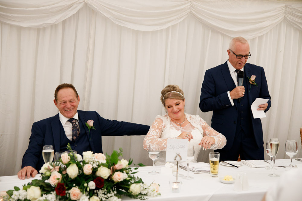 Father of the bride begins his speech, met with wide smiles.