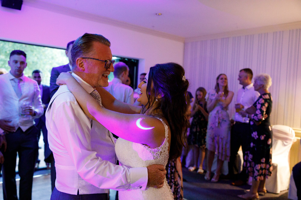 Kyra shares a tender father-daughter dance beneath the warm evening glow.