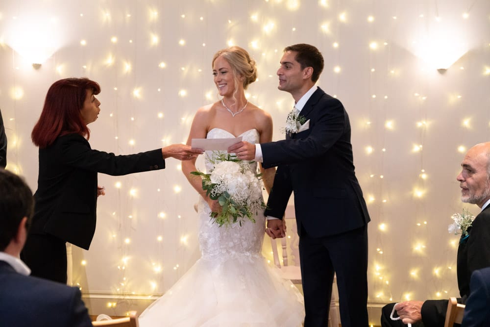 Registrar hands the official wedding certificate to Helen and Adam.