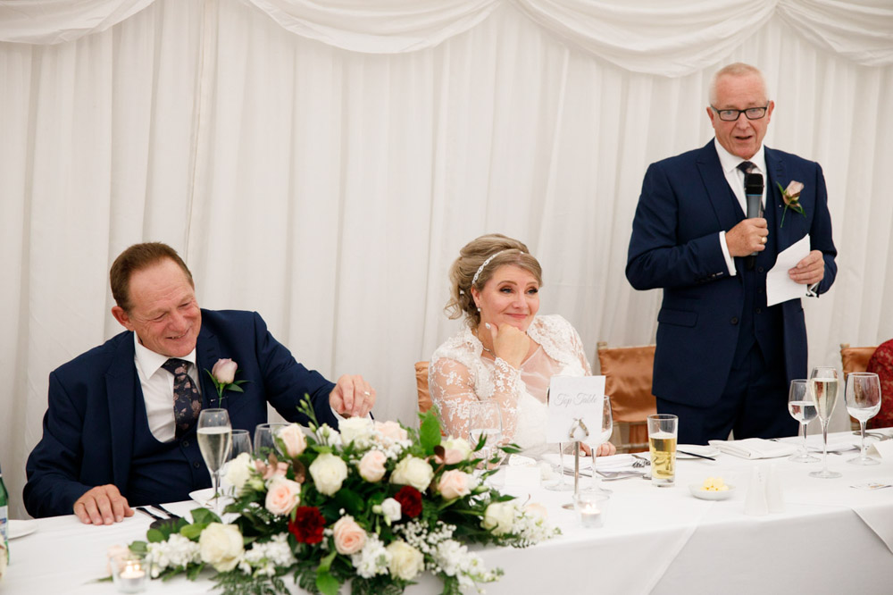 Tracy grins and Gary smiles as the speech continues.