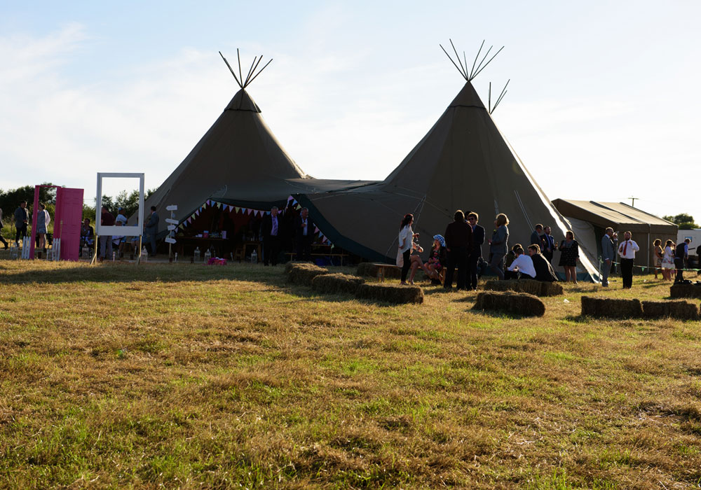 Guests outside the Papakata tents in golden summer evening light.