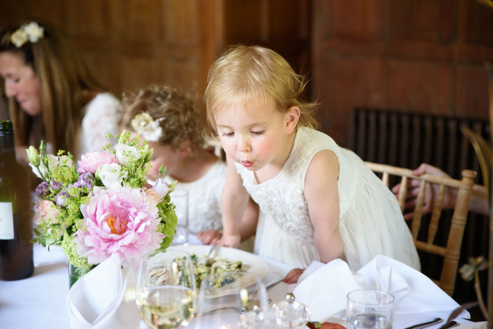 Little toddler blowing on her hot food to cool it down.