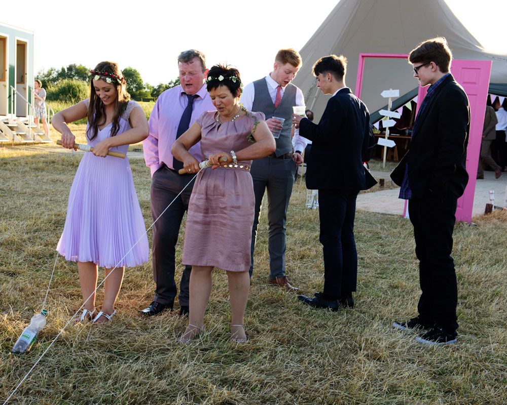 Guests play a ‘reel in the ferret’ wedding game outside the tent.