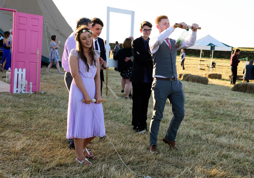 Wedding guest plays a hand dexterity game, smiling and tired.
