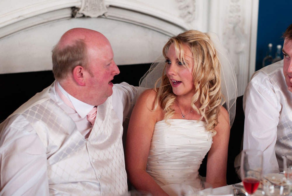Bride’s father wraps his arm around her during the wedding breakfast at Allerton Castle