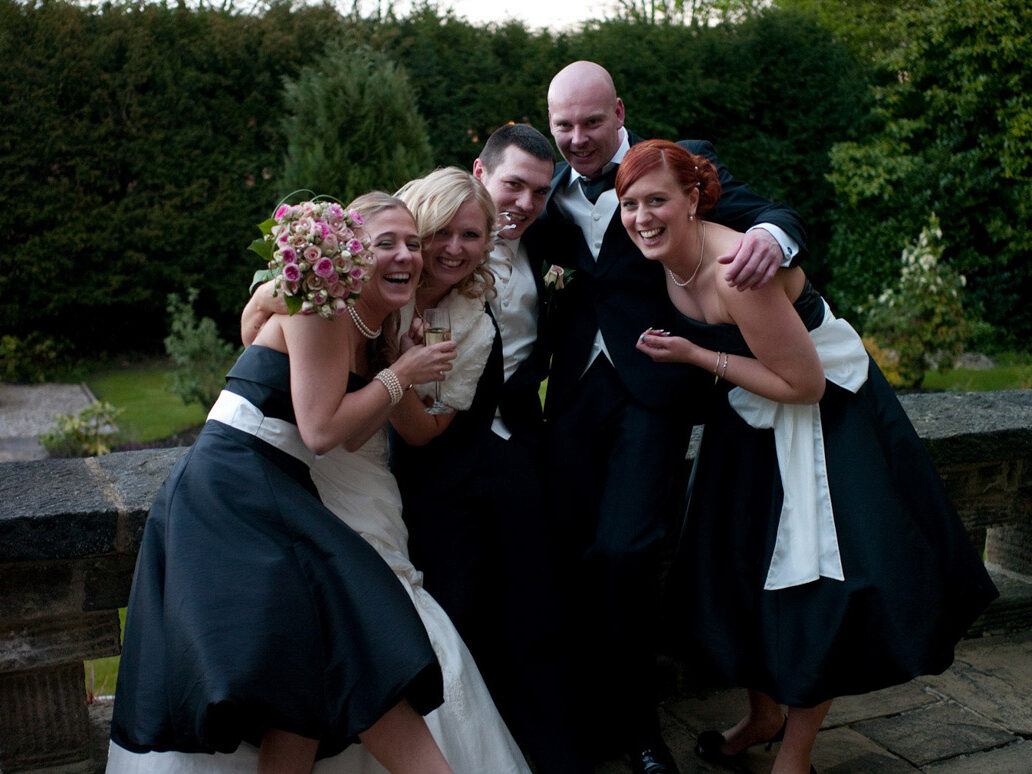 Hoyle Court Baildon wedding - Dani & Scott - friends huddled together for an evening reception photo with the couple.