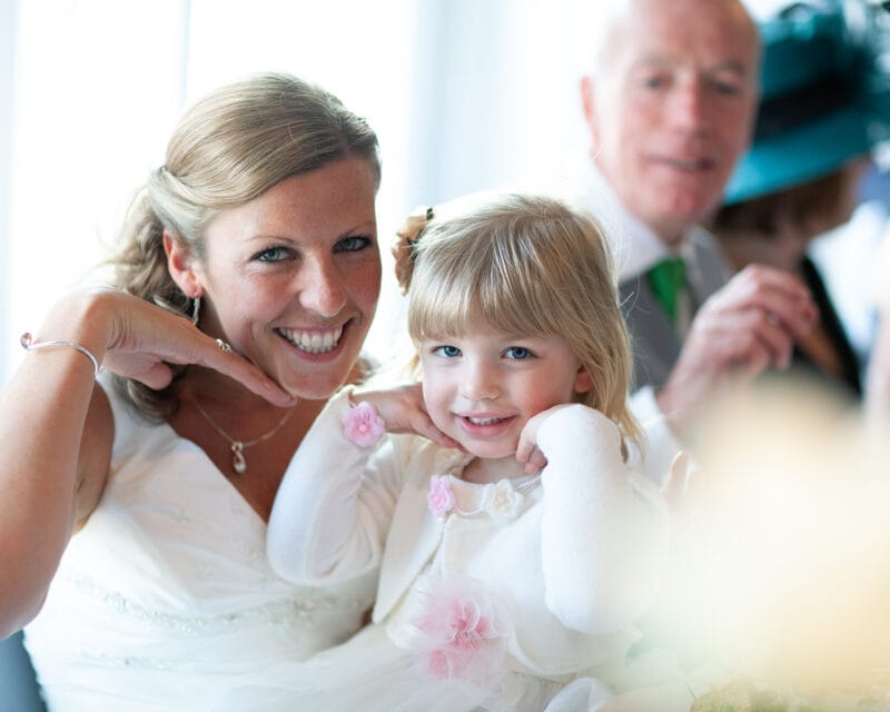 Bride and daughter posing sweetly at the top table during the wedding breakfast