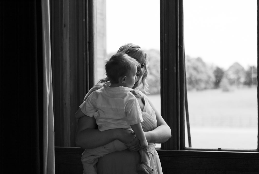 A little boy and his mother look out of the window in soft black and white