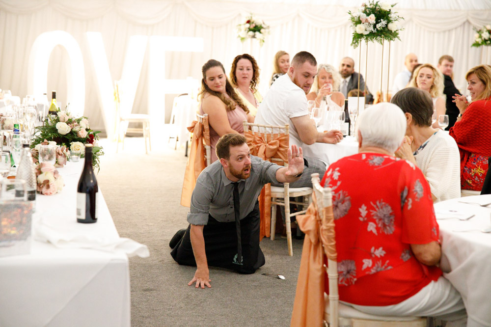 Waiter on the floor playfully fakes a fall before the surprise begins.