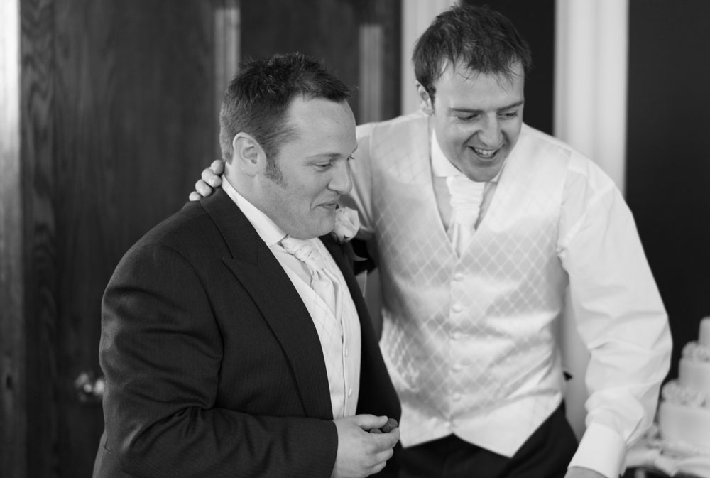 The groom with his hand on the best man's shoulder, a proud moment together