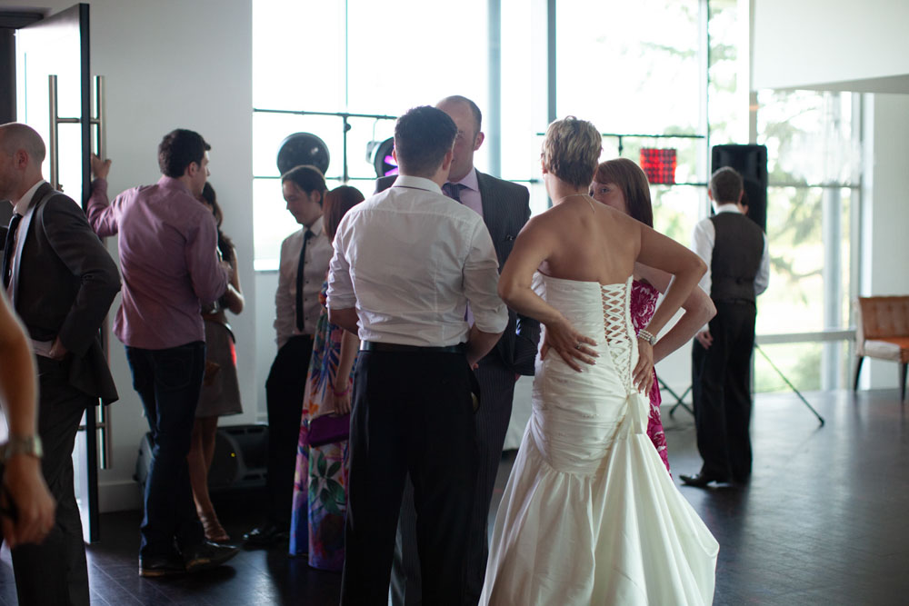 Wide shot of the reception room glowing with warm, soft light and guests mingling.