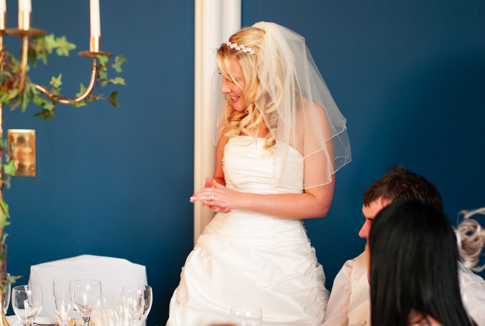 The groom leans in to greet guests during the wedding breakfast