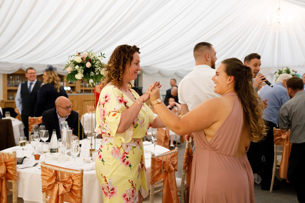 Guests stand and begin to dance across the room.