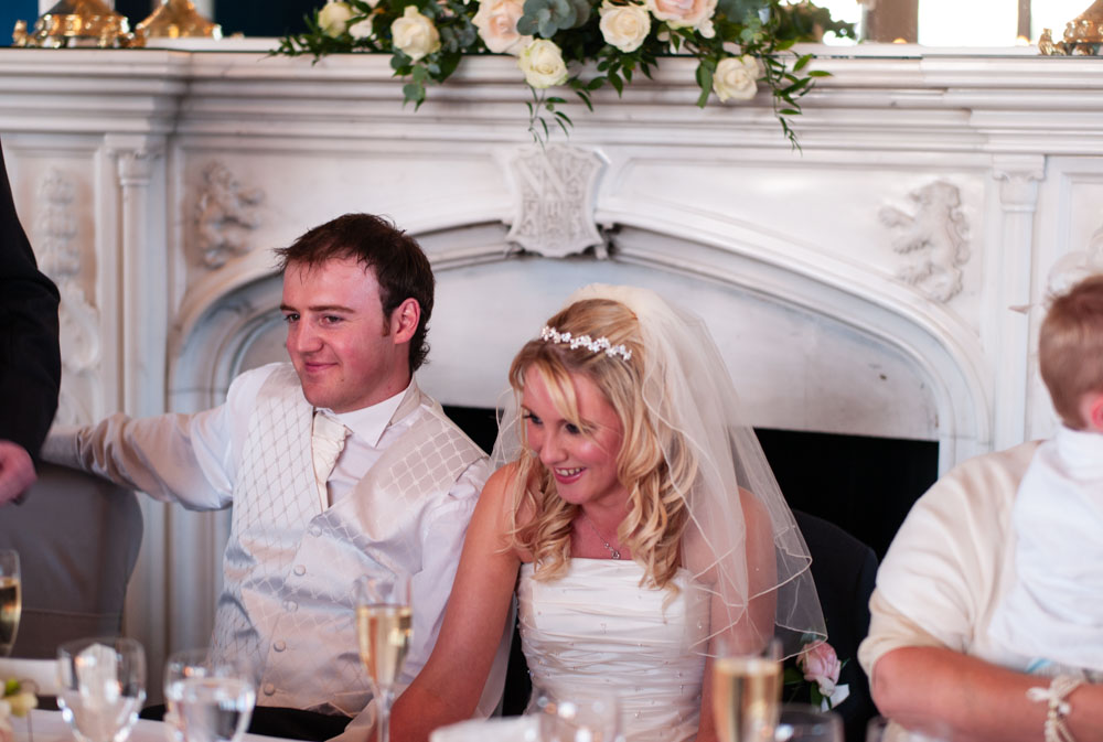 Lee smiles while Vicky hides a bit of embarrassment — light-hearted speech moment