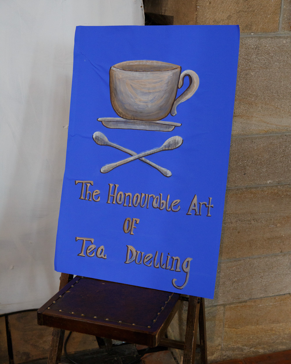 Guests take part in playful tea duelling beneath a handmade sign