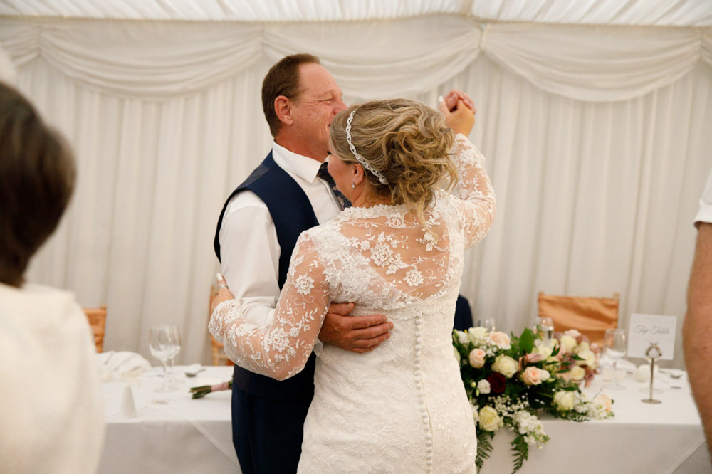 Tracy and Gary arm in arm, sharing a spontaneous first dance.
