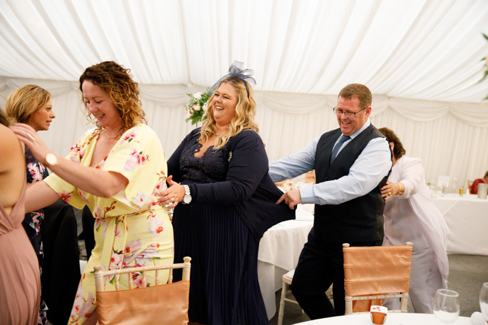Guests form a conga line winding through the room.