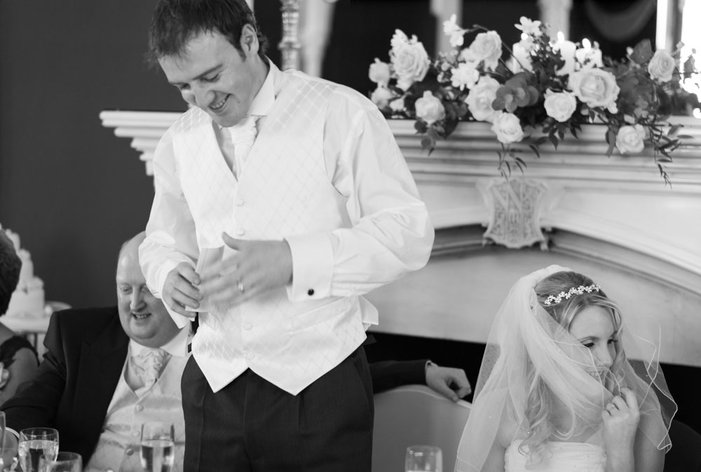The groom begins his speech while Vicky gently lifts her veil to the side
