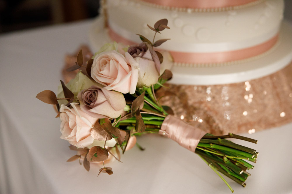Wedding cake and bouquet displayed together before cutting.