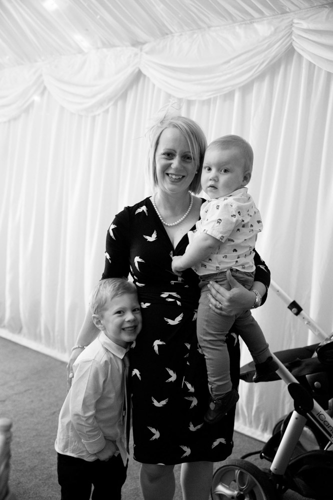 A mother and her two young children smiling for the camera.