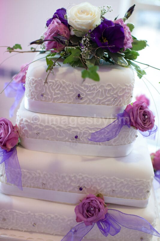 Wedding cake with pink, blue, purple, and white floral decorations