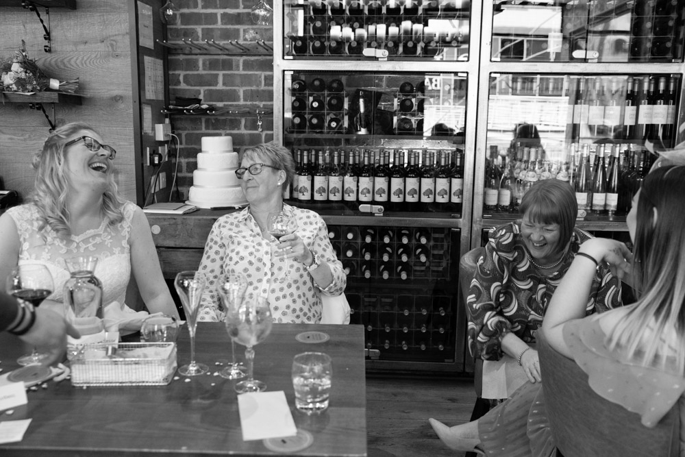 Black and white photo of Clare laughing with a guest