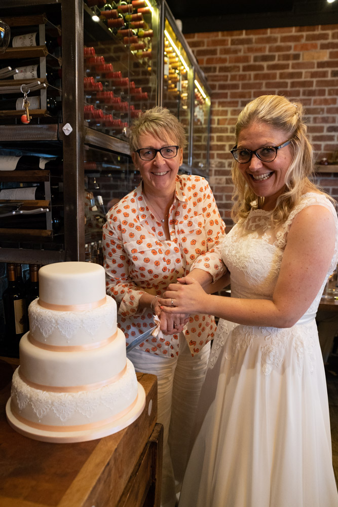 The couple cutting their four-tier wedding cake at Fazenda Leeds