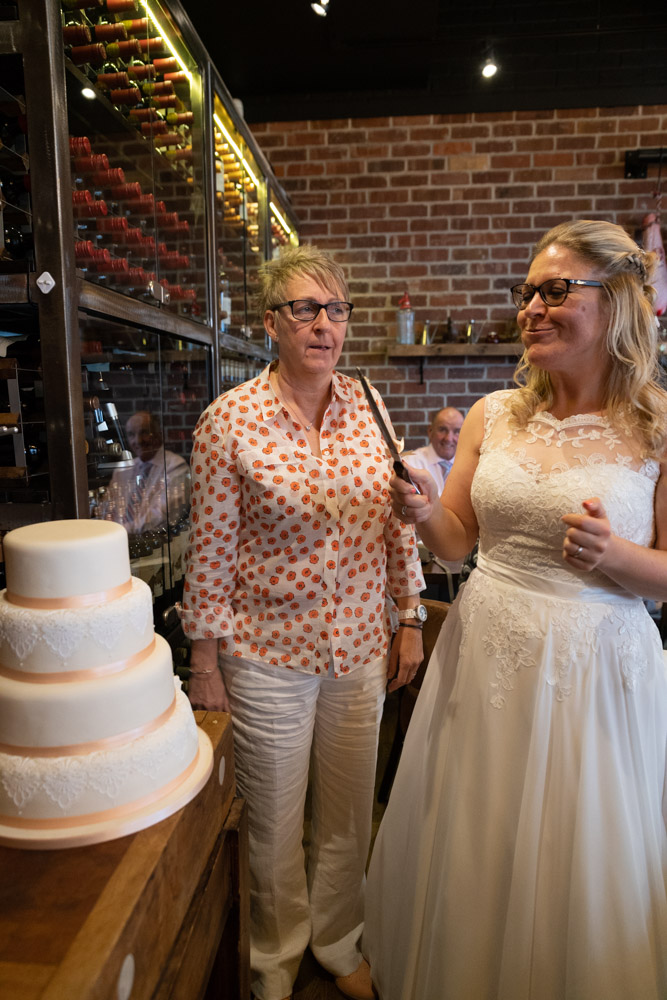 Tracey playfully watches Clare take a bite of cake