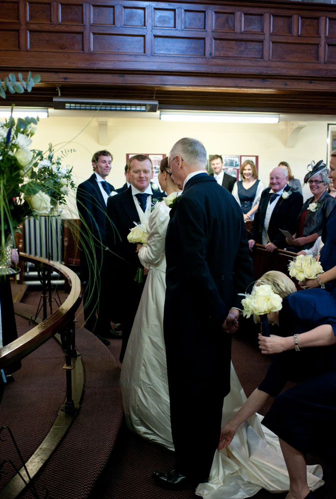 The bride and groom meet at the altar with soft smiles.