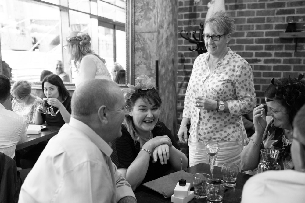 Tracey walking between tables, chatting with loved ones