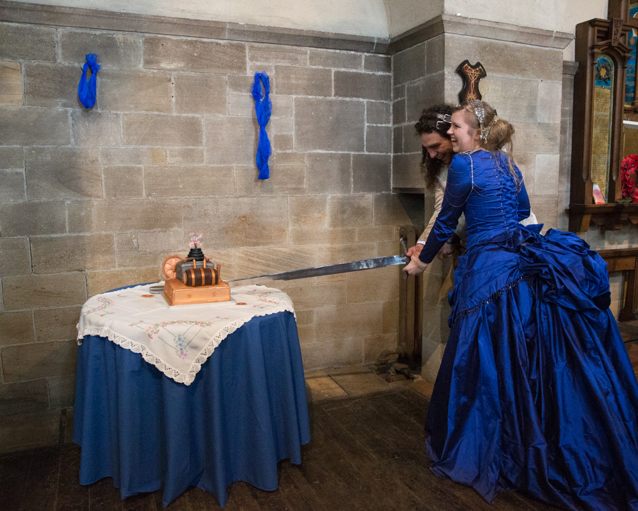 The couple cut their cake together using a ceremonial sword