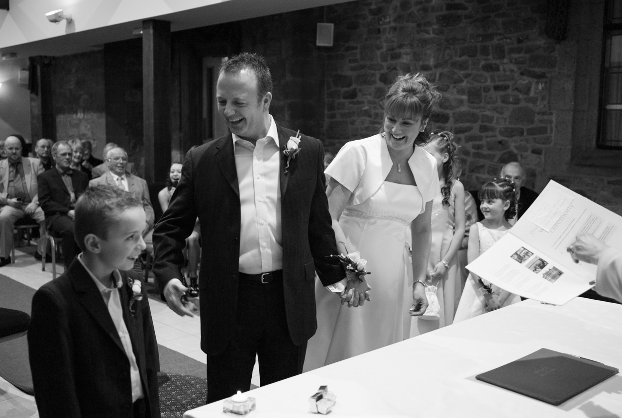 Couple smiling at their son during the ceremony