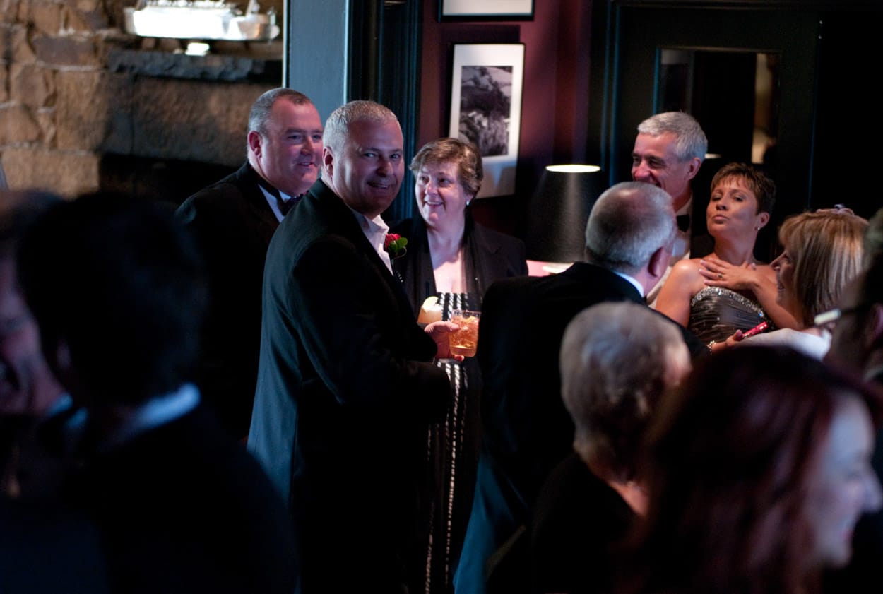 Groom noticing the camera while a friend poses playfully for a candid photo.