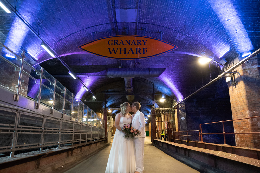 The couple share a kiss beneath glowing blue lights