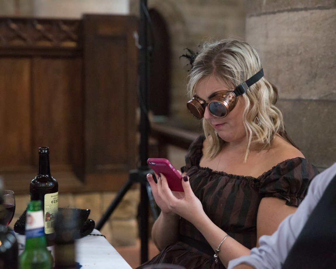 177 guest in steampunk theme goggles checks her phone left bank leeds wedding reception linsey and chris
