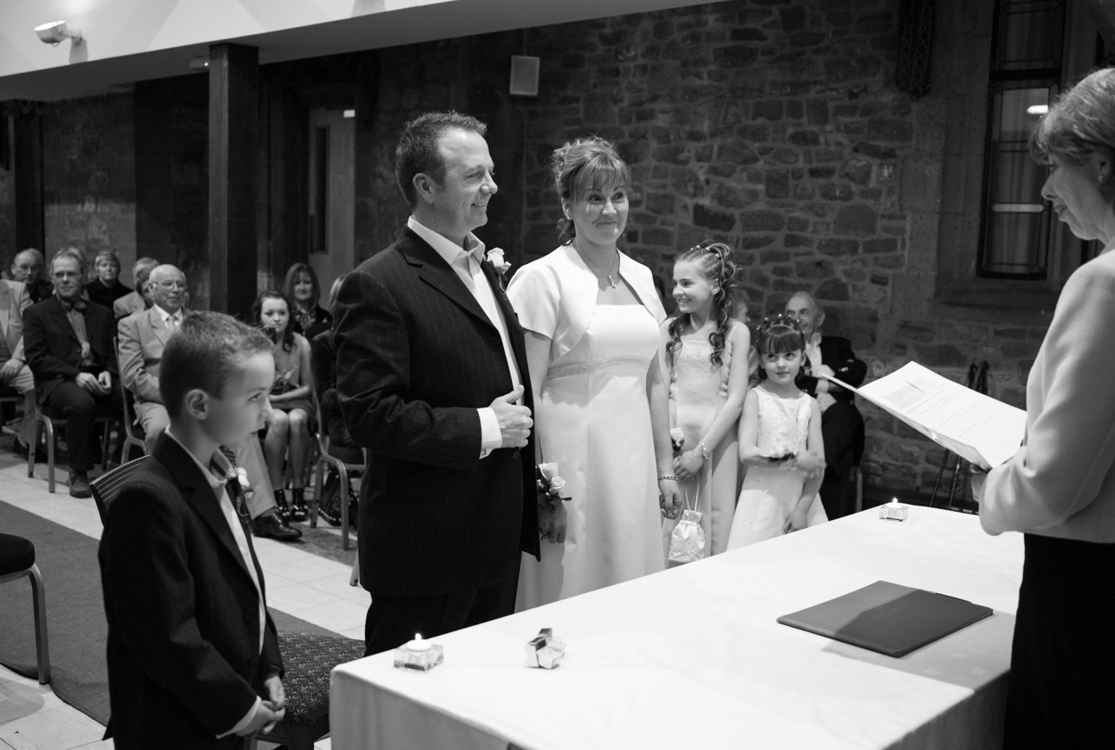 Bride and groom reacting with smiles during the registrar’s words