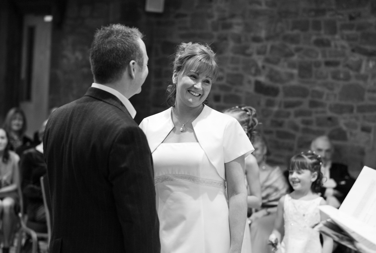 Natural smiles from bride and groom during the ceremony