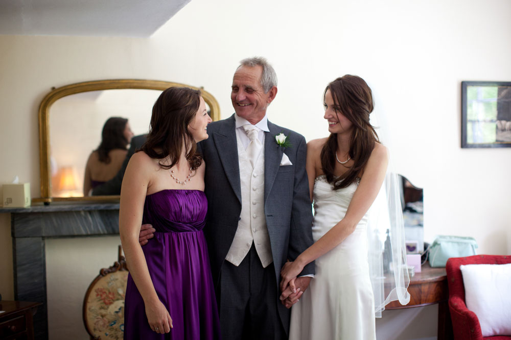 Bride and father look at the bridesmaid (sister)