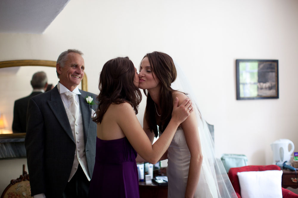 Bridesmaid kisses her sister - the bride