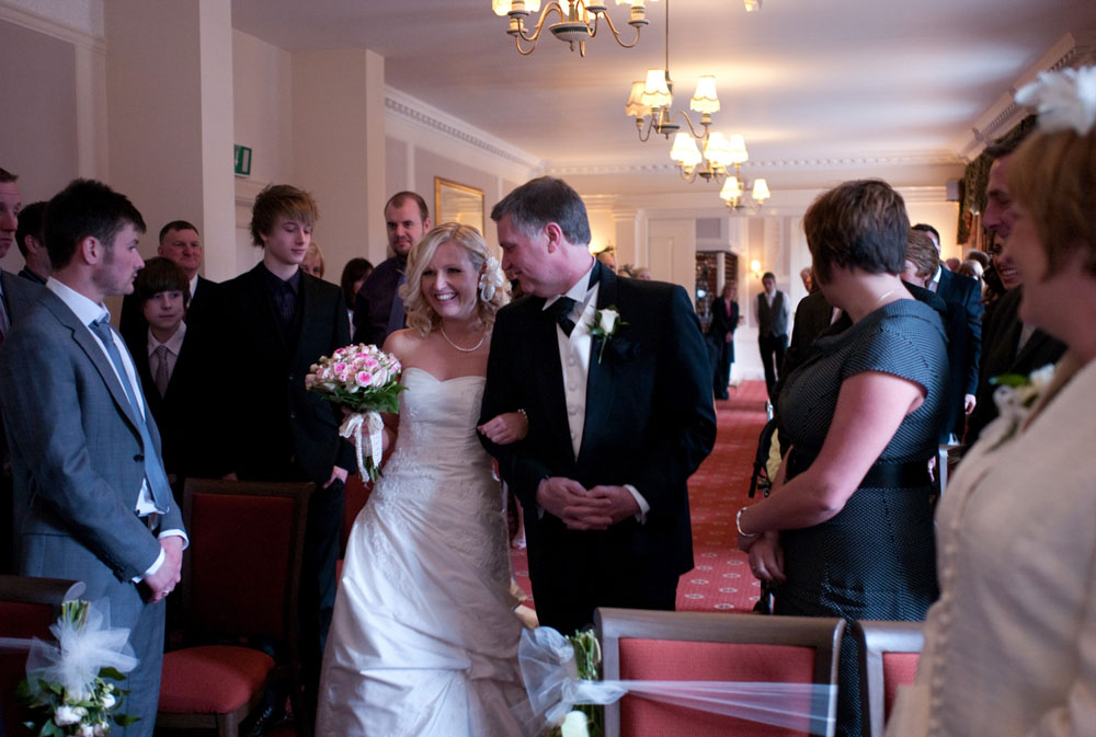 Dani, the bride walks in with her father