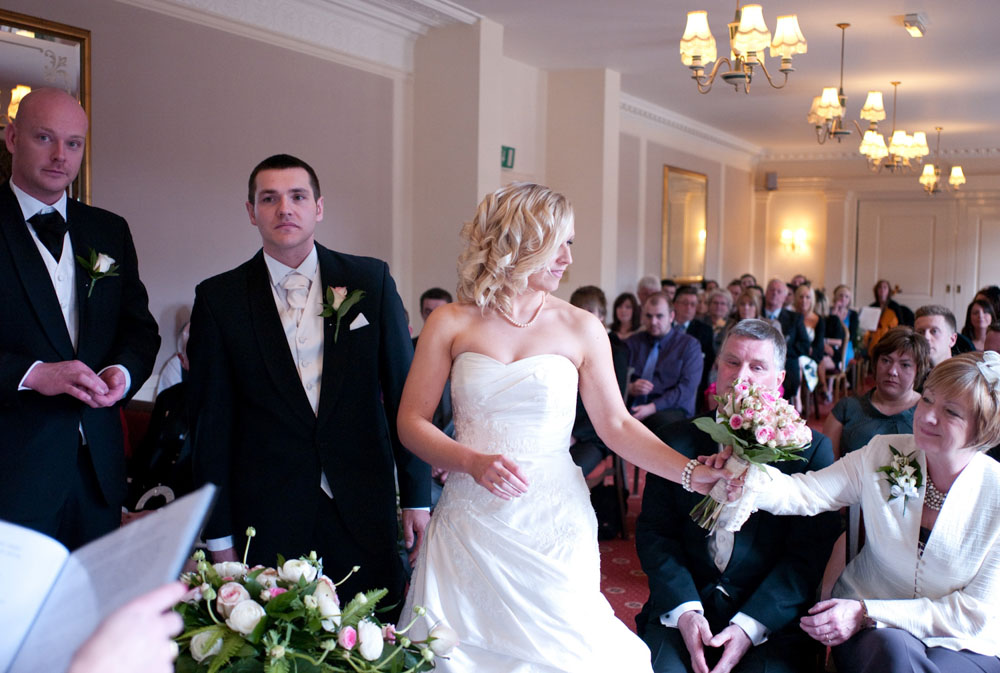 Bride passes her mom her bouquet