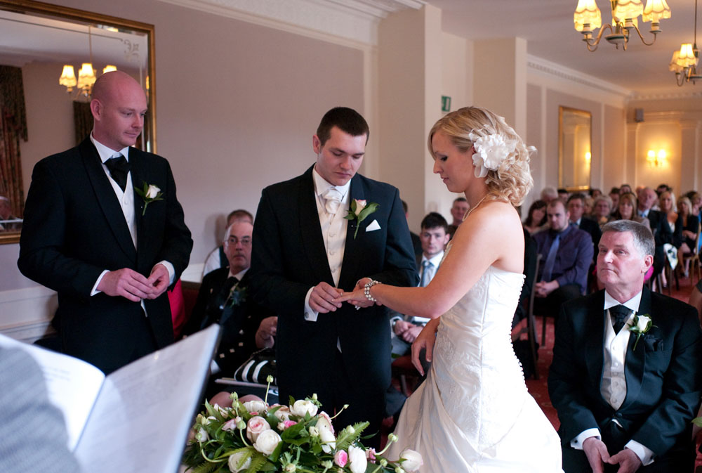 Groom places a ring on the bride's wedding finger