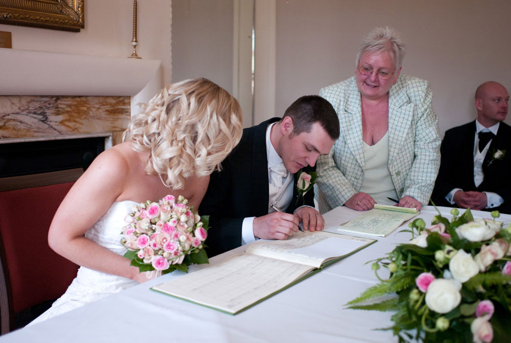 The groom signs the register - Hoyle Court wedding photography