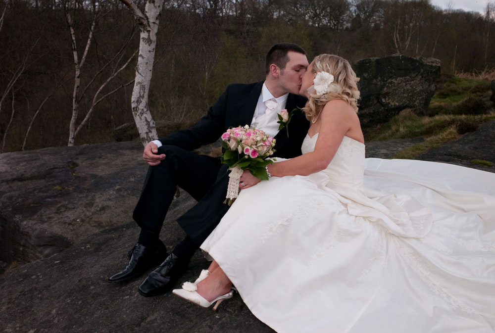 Couple sit on rocks for a lovely April photo - Hoyle Court wedding photography