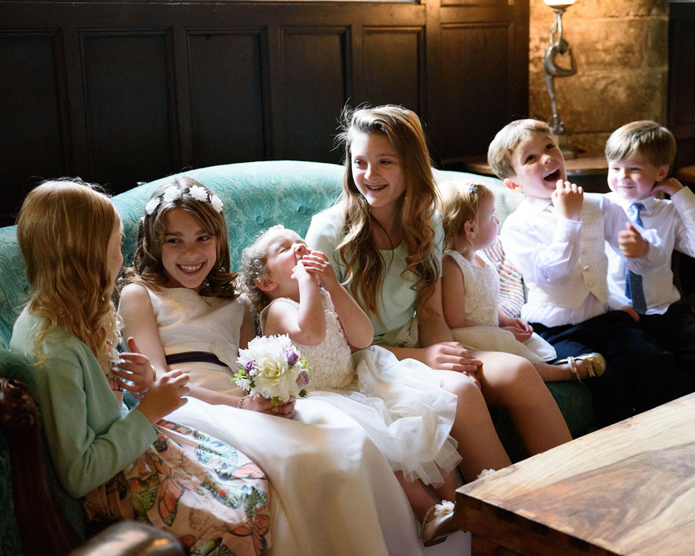 Children chatting and smiling during a group photo on the sofa