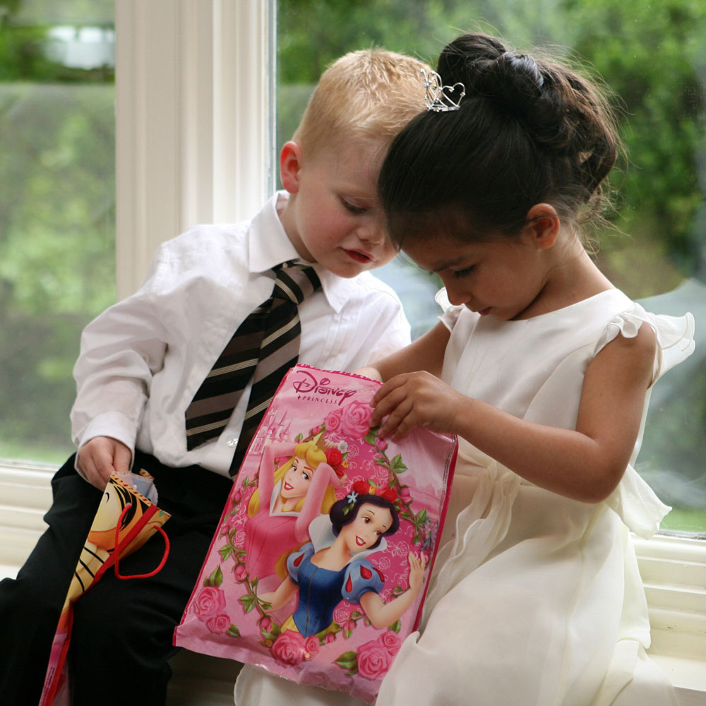 Little boy looking at what a little girl received as a gift